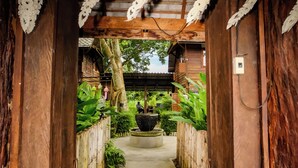 A wooden corridor with hanging lanterns, a concrete path, and wooden walls. - Pastela Doi Saket Villa & Spa (Doi Saket)