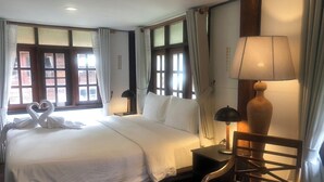 A hotel room with a large bed, two bedside tables, a lamp, and curtains. - Pastela Doi Saket Villa & Spa (Doi Saket)