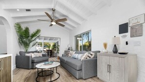 A modern living room with a grey sofa, a round coffee table, and a cabinet. - The Riverside Retreat #2 (Fort Lauderdale)
