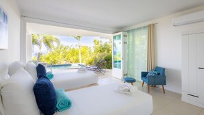 Habitación de hotel moderna con cama, una silla y vistas a una piscina y vegetación.
