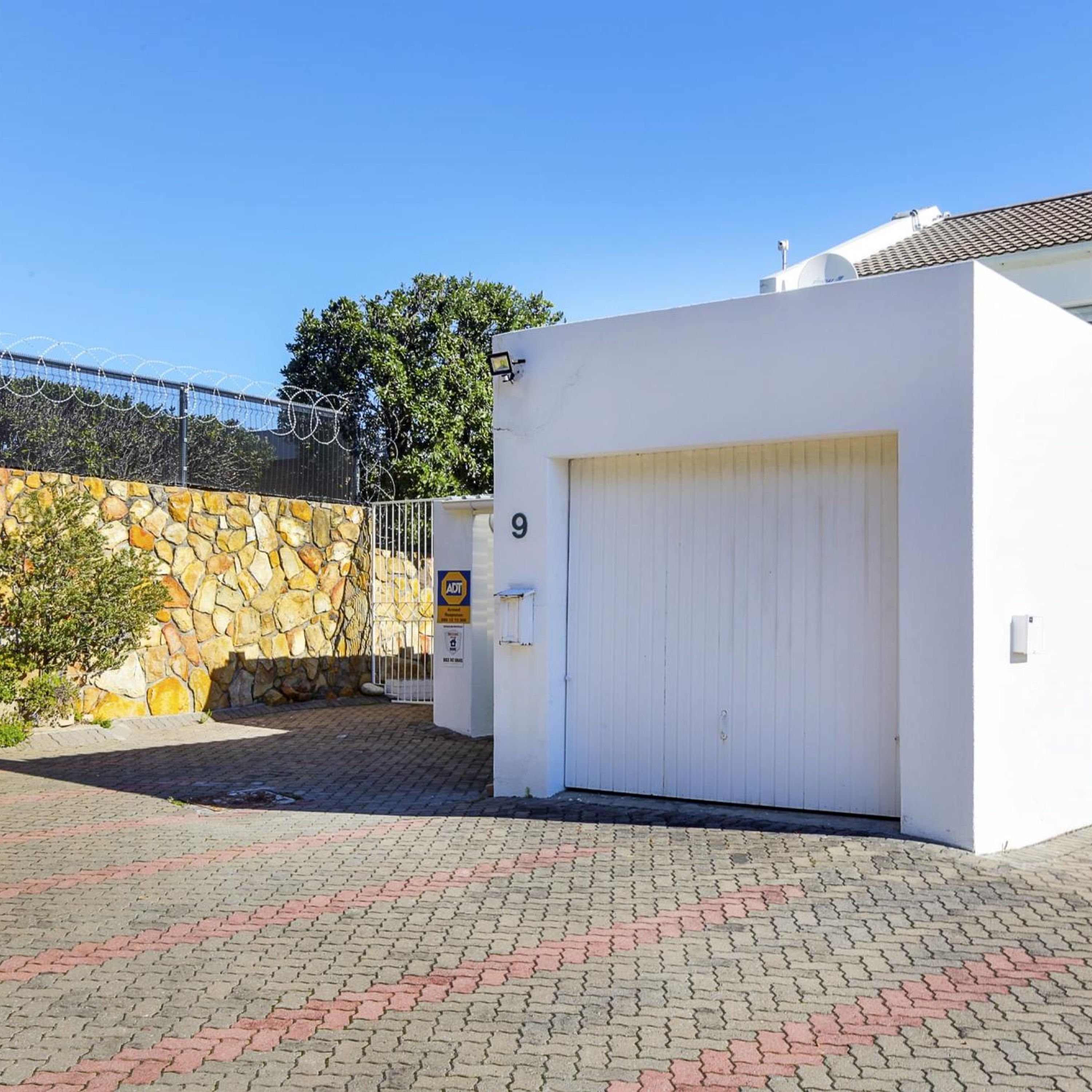 A building with a stone wall and a white garage door.