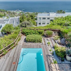 Una piscina sul tetto con vista sul mare e sugli edifici circostanti.