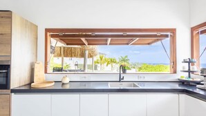 A kitchen with a large window, a sink, and a wooden countertop. - Gosa Di Bida I Private Pool (St. Marie)