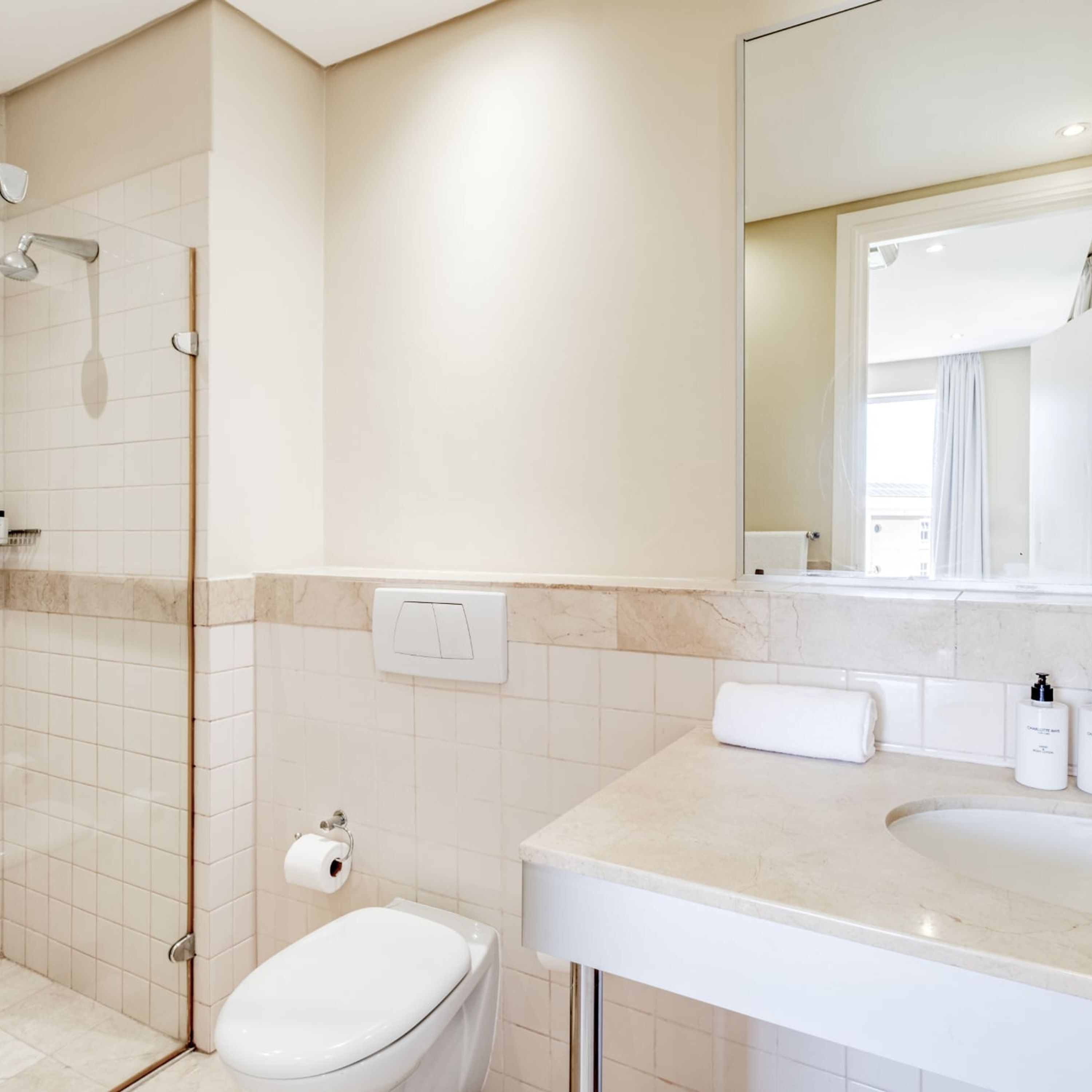 Ein modernes Badezimmer mit Dusche, Toilette, Waschbecken und Spiegel.