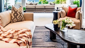 A modern living room with a sofa set, a coffee table, and a view of the ocean. - Luxurious Villa w Sea City Views Splendor Views (Cape Town)