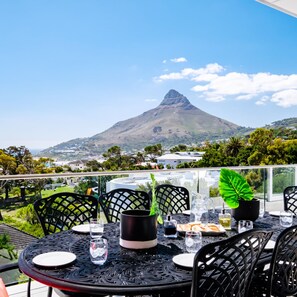 A table set for dining with a view of a mountain. - Elegant Apartment w Ocean Views Quenera Apartment (Cape Town)