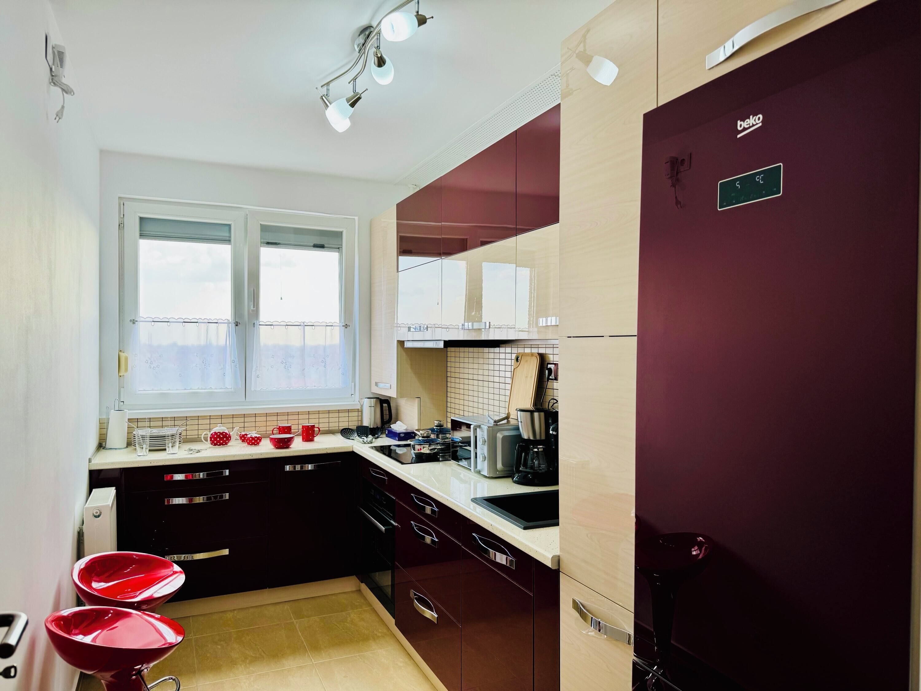 A compact kitchen with a window, a refrigerator, and a sink.