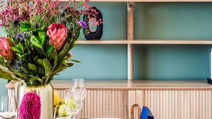 A wooden shelf with wine glasses and a vase of flowers. - Picturesque Seaside Haven Aretzi (Cape Town)