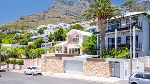 A residential area with modern houses, a palm tree, and a mountain in the background. - Elegant Charm Retreat Central Treasure (Cape Town)