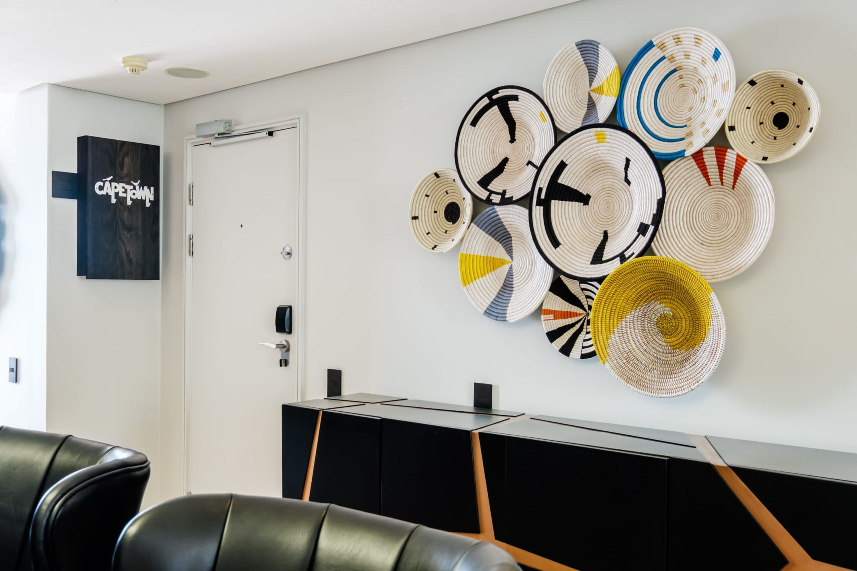 A modern interior with a wall-mounted clock and a framed artwork.