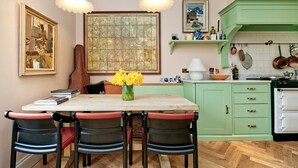 A kitchen with a dining table, chairs, a map, and a stove. - Charming 1 Bedroom 1 Bathroom Notting Hill (London)