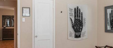 A bedroom with a white door, a handprint artwork, and a bed.
