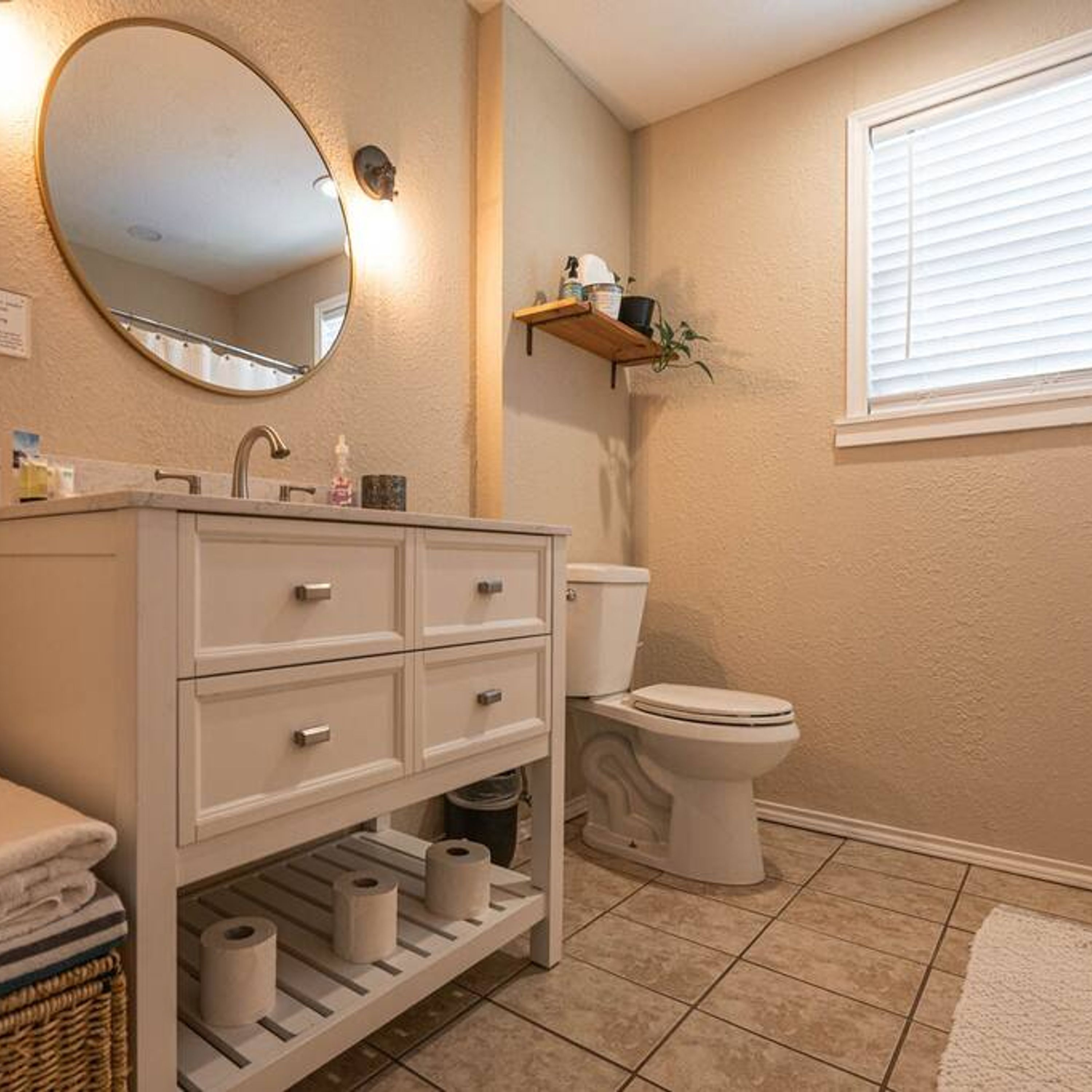 Une salle de bain avec un meuble-lavabo blanc, des toilettes et un miroir.
