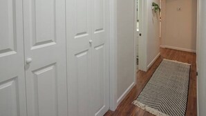 Un couloir avec des portes blanches et une enseigne indiquant « LAVAGE ET SÉCHAGE ».