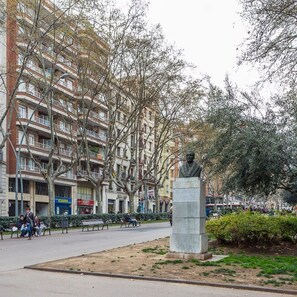 Una estatua en un parque con un edificio de varios pisos al fondo.