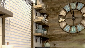 A kitchen with a wooden wall, a clock, and shelves with dishes. - The Shoreline Container Tiny Home 12 min to Magnolia Baylor (Waco)