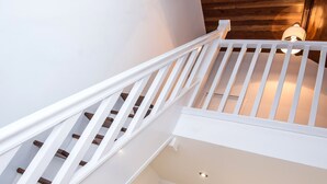 A staircase with white railings leading to a second floor. - The Tunstall (Durham)
