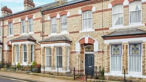 A row of terraced houses with brick facades, bay windows, and a black front door. - Host Stay Belle Vue (Saltburn-by-the-Sea)
