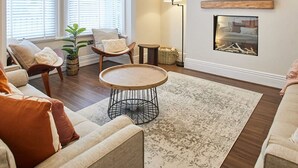 A living room with a sofa, armchairs, a coffee table, a fireplace, and a TV mounted on the wall. - Host Stay Belle Vue (Saltburn-by-the-Sea)
