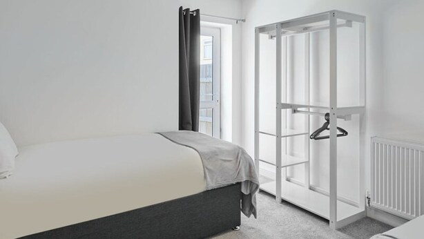 A modern bedroom with a bed, a wardrobe, and a radiator. - Host Stay The Globe Apartment 3 (Guisborough)