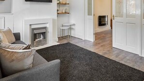 A modern living room with a fireplace, a flat-screen TV, and a cozy seating area. - Host Stay Church Street (Warrington)