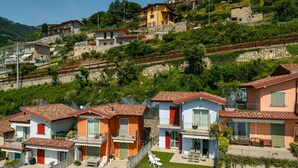 A hillside residential area with houses featuring red-tiled roofs and balconies.