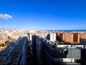 Zona urbana con rascacielos, vista despejada del paisaje de la ciudad y el mar al fondo.