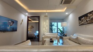 Una sala de estar moderna con un sofá, una mesa de centro, un televisor montado en la pared y un cuadro.