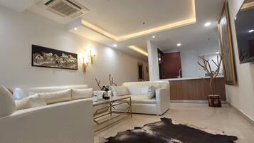 Departamento de lujo, 1 cama King size, vista a la ciudad | Área de sala de estar | Televisión LED de 50 pulgadas con canales digitales y Netflix