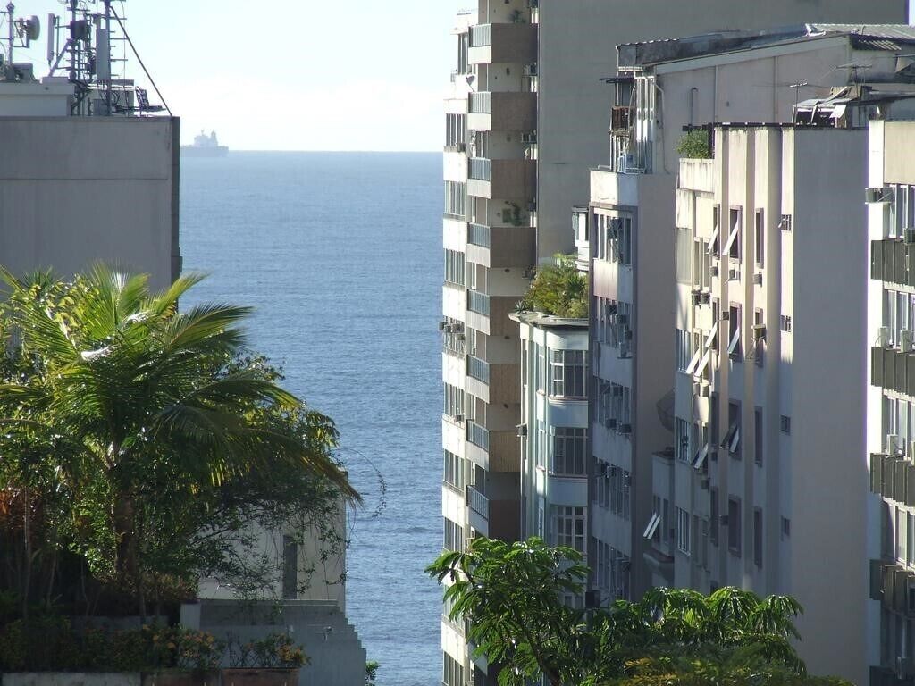 A high-rise building with balconies overlooking a body of water.