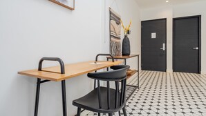 Una hall d'albergo moderna con una scrivania in legno, sedie nere, un pavimento decorato e una porta nera.