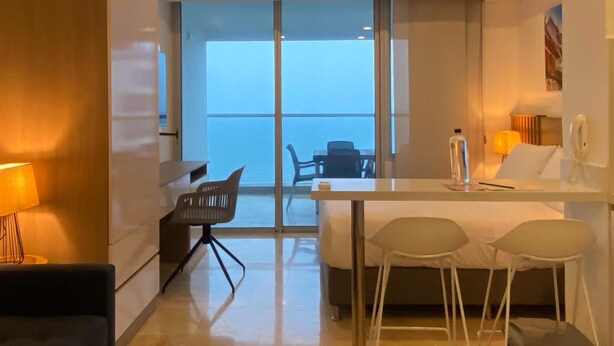 A modern hotel room with a balcony, a dining area, and a ceiling fan. - w Marvelous Loft With Balcony in Crespo (Cartagena)