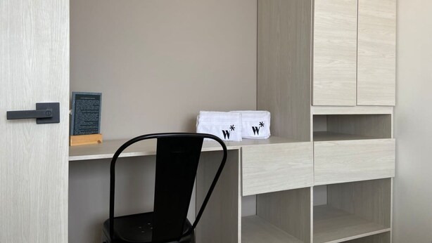 A minimalist room with a wooden desk, a black chair, and a white cabinet. - w Magnificent 1BR With Terrace at Poblado (Medellín)