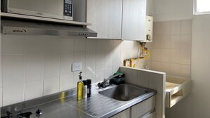 A kitchen with a microwave, stove, sink, and cabinets. - w Magnificent 1BR With Terrace at Poblado (Medellín)