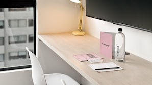 Un bureau avec une lampe, une bouteille et quelques feuilles de papier.