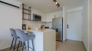 A modern kitchen with a central island, bar stools, a microwave, and a refrigerator. - w Radiant 1BR w Modern Balcony in San Francisco (Panama City)