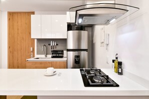 A modern kitchen with a stainless steel refrigerator, a built-in coffee machine, and a gas stove. - Lovely Loft With Modern Deco in Chapinero (Bogotá)