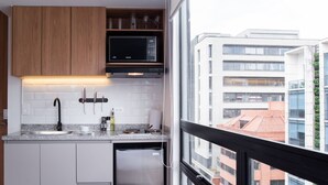 A modern kitchen with white cabinets, a stainless steel dishwasher, and a black microwave. - w Splendid Loft w Fantastic Deco in Bogota (Bogotá)