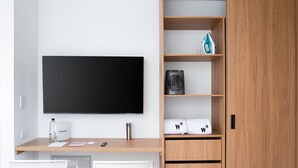 A modern room with a flat-screen TV, a desk with a computer, and a wardrobe with shelves. - w Splendid Loft w Fantastic Deco in Bogota (Bogotá)