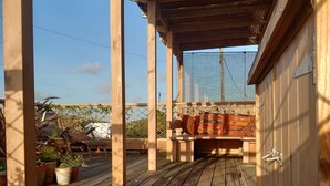 A wooden deck with a covered seating area and potted plants. - The Crabshack Cottage Normans Bay Pevensey (Pevensey)