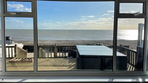 A view from a room with large windows overlooking a beach. - Exquisite Beachfront Residence With Luxurious Interiors The Cozy Clam Pevensey Bay (Pevensey)