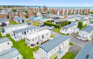 A residential area with mobile homes and detached houses, featuring a road and a view of the sea. - Your Ultimate Holiday Rental at Pevensey Bay (Pevensey)