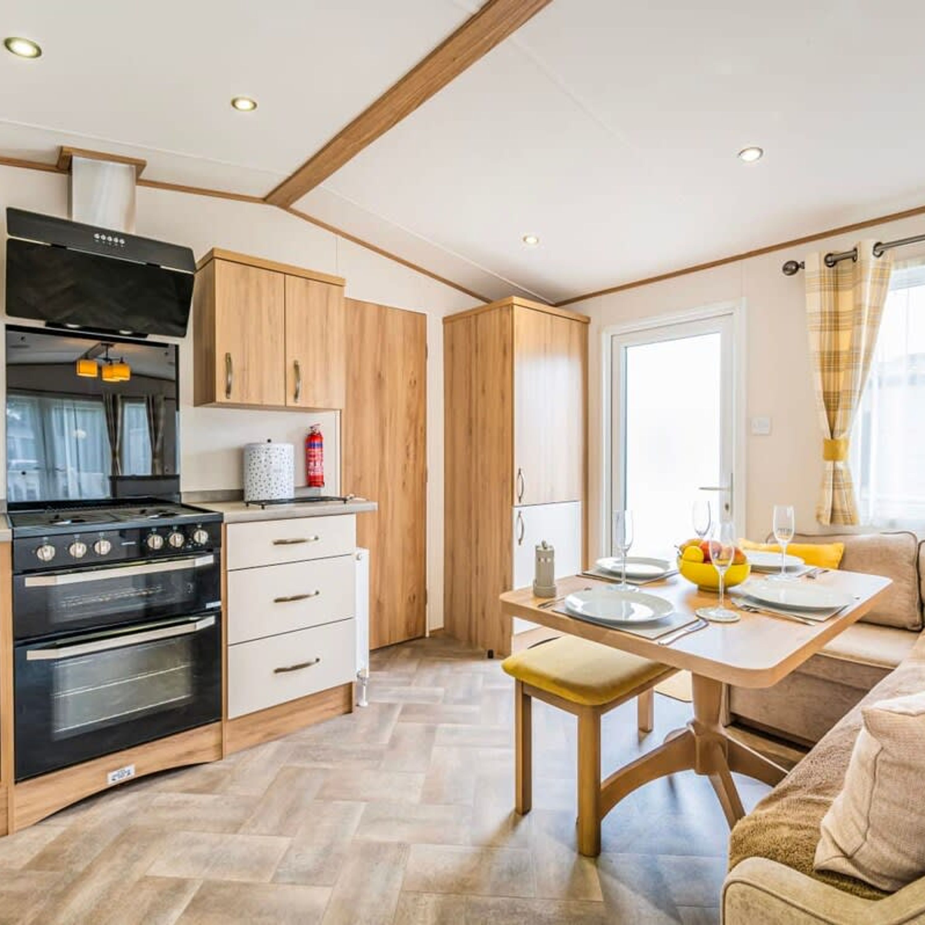 A compact kitchen with a stove, oven, and wooden cabinets.