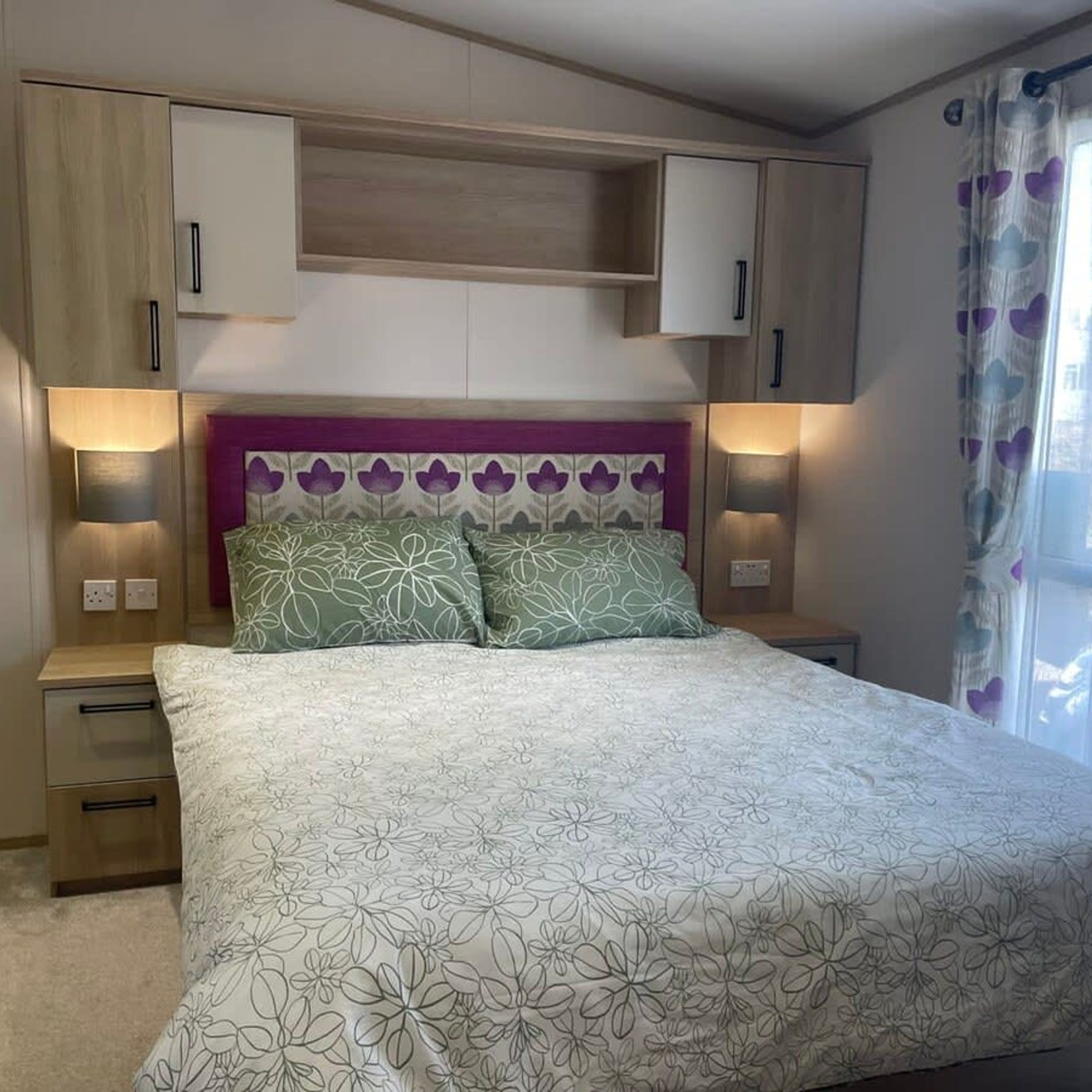 A bedroom with a bed, nightstands, and built-in cabinets.