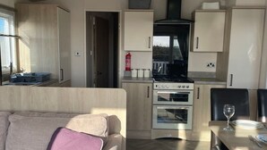 A compact living space with a kitchenette, a sofa, and a dining area.