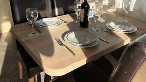A dining table set for four with wine glasses, plates, and cutlery.