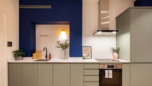 Una cocina moderna con una pared azul de acento, un fregadero, una estufa y un lavavajillas.