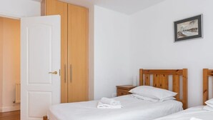 A bedroom with two wooden beds, a white door, and a painting on the wall. - Ferncourt Stepaside (Dublin)