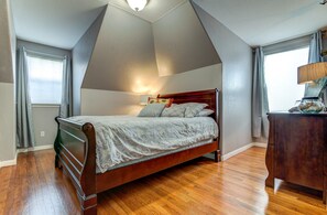 A bedroom with a wooden bed, a nightstand, a lamp, and a window with curtains. - Spacious 3BR Retreat Close to Downtown & Outlets (San Marcos)