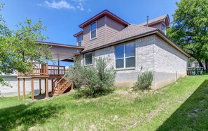 A two-story house with a covered porch and a small staircase leading to a deck. - Spacious 3BR Retreat Close to Downtown & Outlets (San Marcos)